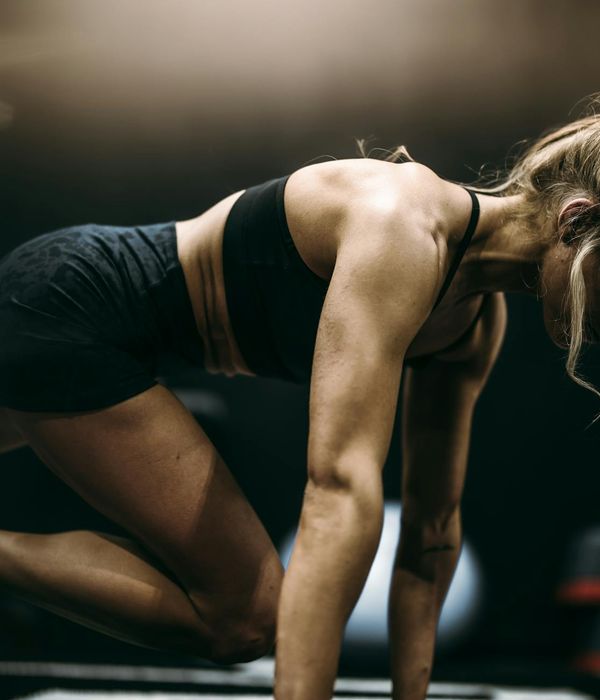 Woman performing a dynamic cardio movement with focus and energy.